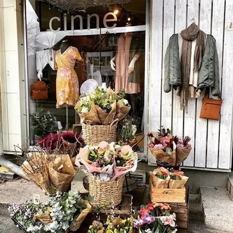 Cinnes skyltfönster med blommor och kläder vid entrén